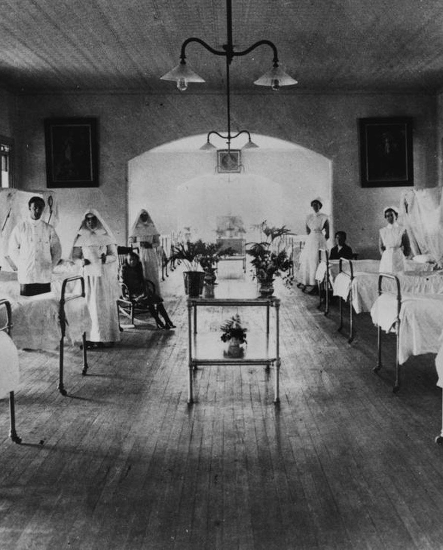 The women's surgical ward at the Mater Misericordiae Hospital, South Brisbane, photographed in 1914, with nursing staff and Sisters of Mercy standing between the beds